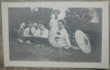 Grup de domnisoare, tarani curatind copaci in fundal/ fotografie