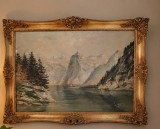 Tabloul &icirc;nfățișează un peisaj montan cu lac realizat &icirc;n tehnica ulei pe p&acirc;nză, &icirc;ncadrat &icirc;ntr-o ramă decorativă aurită, stil Baroc
