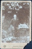 Fotografie tip CDV, Barbat la masa (Nae Andreescu comerciant), in gradina, inceput de secol XX