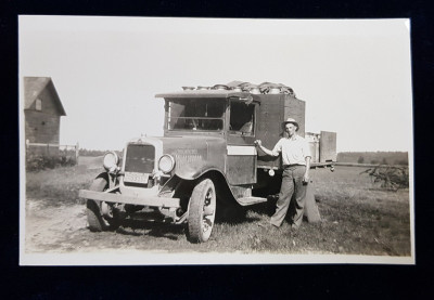 TANAR POZAND LANGA O CAMIONETA CARE TRANSPORTA LAPTE DE LA O FERMA LA ORAS , FOTOGRAFIE TIP CARTE POSTALA , MONOCROMA, PE HARTIE LUCIOASA , PERIOADA I foto