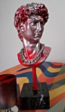Bust David cu postament marmură 26 cm h. Culoare roșie cu argintiu. Lanț gros argintiu, mobil, la g&acirc;t. Bust rășină 14 cm h pe bază marmură neagră