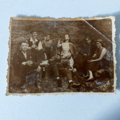 Fotografie cu grup de barbati femei si 1 copil, la munte, cu sticle de bere