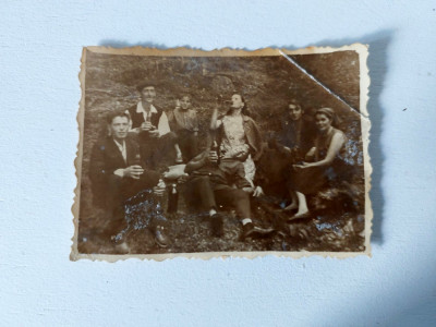 Fotografie cu grup de barbati femei si 1 copil, la munte, cu sticle de bere foto