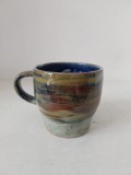 Cana ceramica cu toarta, lucrata manual, cu glazura in nunte albastre-maronii-galeben, 8.5cm inaltime x 9cm diametru la gura