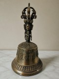 Clopot ritual tibetan din bronz, cu un finisaj antichizat și un m&acirc;ner sculptat