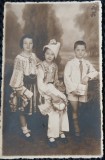 Fotografie tip Carte Postala, Doua fetite in costume nationale romanesti si un baietel, perioada interbelica