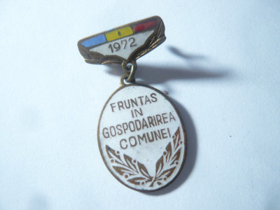 Insigna Fruntaș &amp;icirc;n gospodărirea comunei 1972 , h=3,5cm , metal si email foto